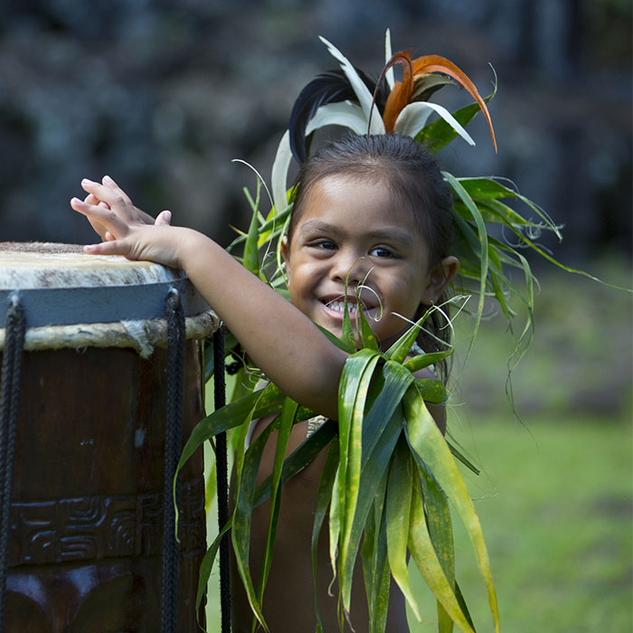 young tahitian local playing large tahitian drum